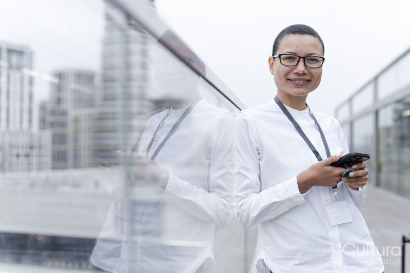 Non binary office worker posing against office buildings