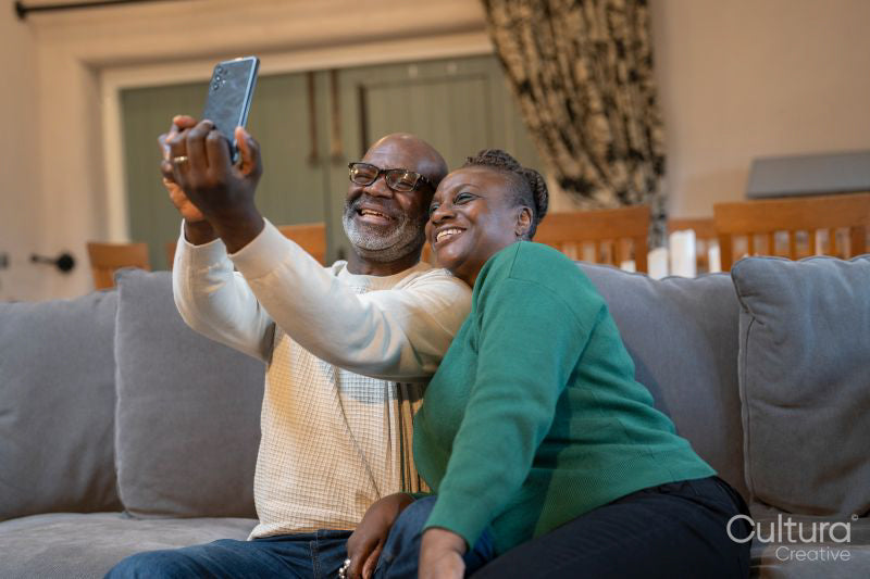 Smiling senior couple taking selfie at home