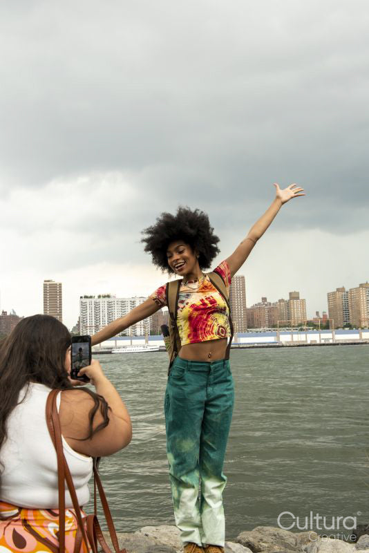Two women taking pictures by river