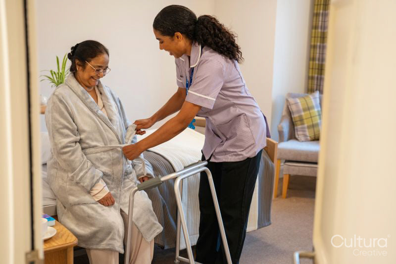 Nurse helping senior lady in her room at nursing home