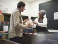 Volunteer giving man vegetables in community food center