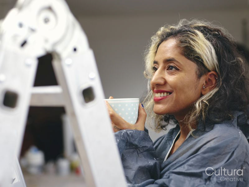 Smiling woman having coffee break during renovation