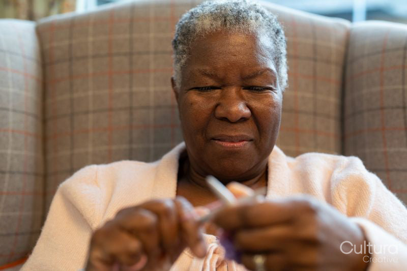 Smiling senior woman knitting in nursing home