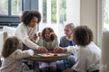 Happy family playing tic tac toe at home