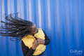 South Yorkshire, Woman with braided hair shaking head against striped wall