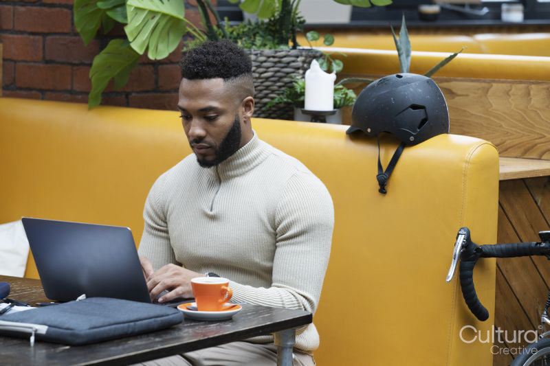 Man sitting in office lounge using laptop