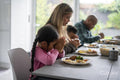 Family praying before eating dinner