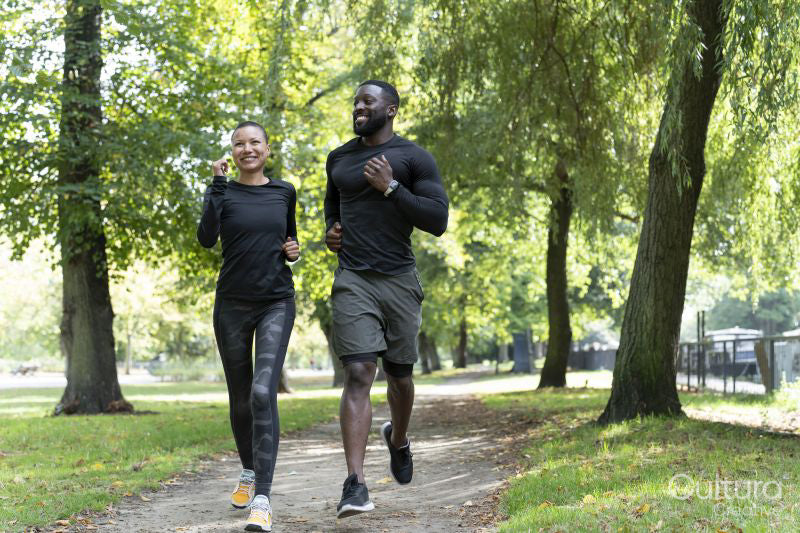 Smiling man and woman jogging in park