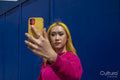 Young woman with yellow hair taking selfie outdoors