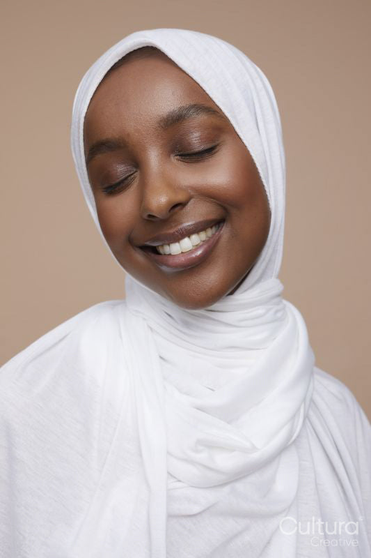 Studio shot of smiling young woman wearing white hijab