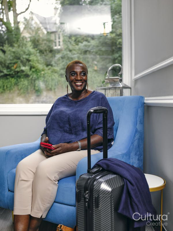 Smiling woman sitting in armchair in hotel lobby