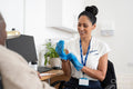 Smiling female doctor putting on protective gloves in office