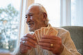 Smiling senior man playing cards at table