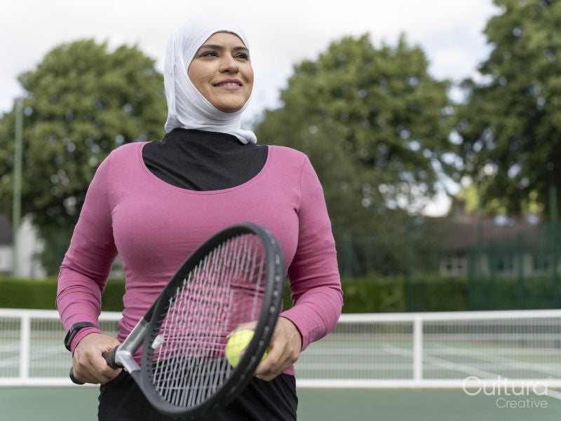 Sutton,Portrait of smiling woman in headscarf at tennis court