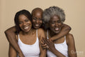 Studio portrait of three smiling women in white tops