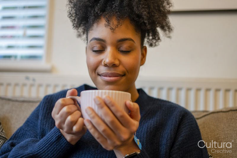 Young woman relaxing with cup of tea
