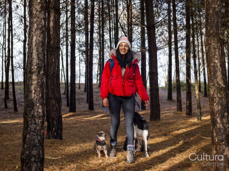 Woman hiking in forest with dogs