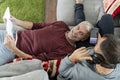 Smiling male couple relaxing on sofa at home