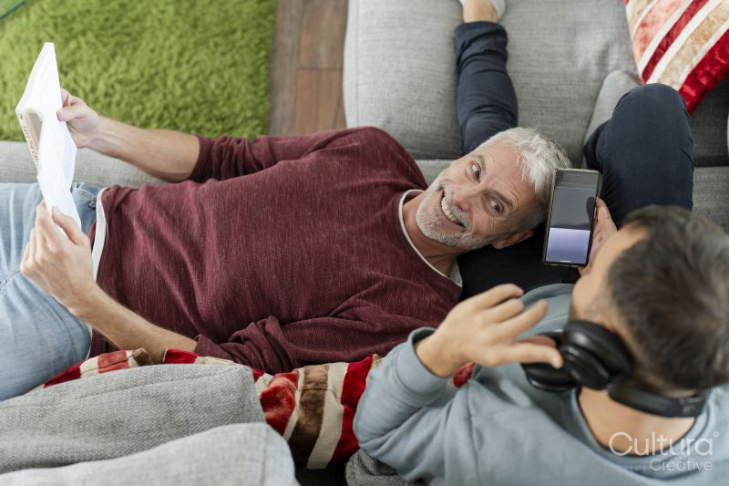 Smiling male couple relaxing on sofa at home