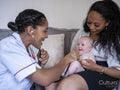 Nurse examining baby girl with stethoscope