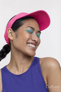 Portrait of smiling woman wearing blue makeup and sun visor