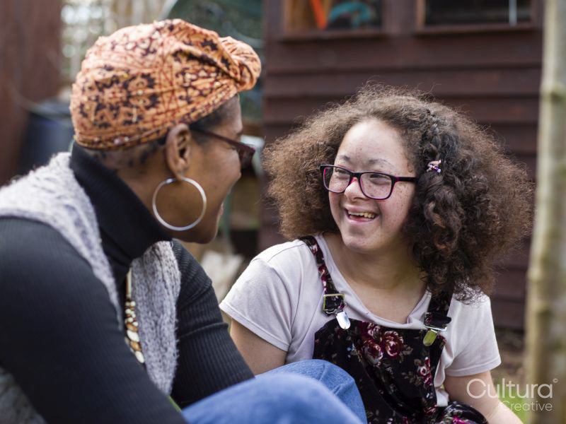 Mother and daughter talking in backyard