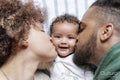 Parents kissing baby daughter