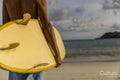 Surfer holding surfboard on beach