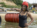 Portrait of smiling woman with wooden raft in lake