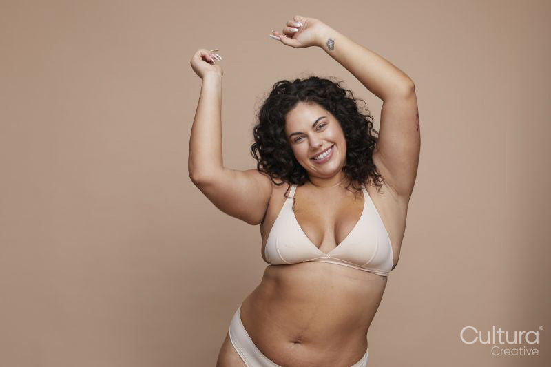 Studio portrait of smiling young woman wearing lingerie