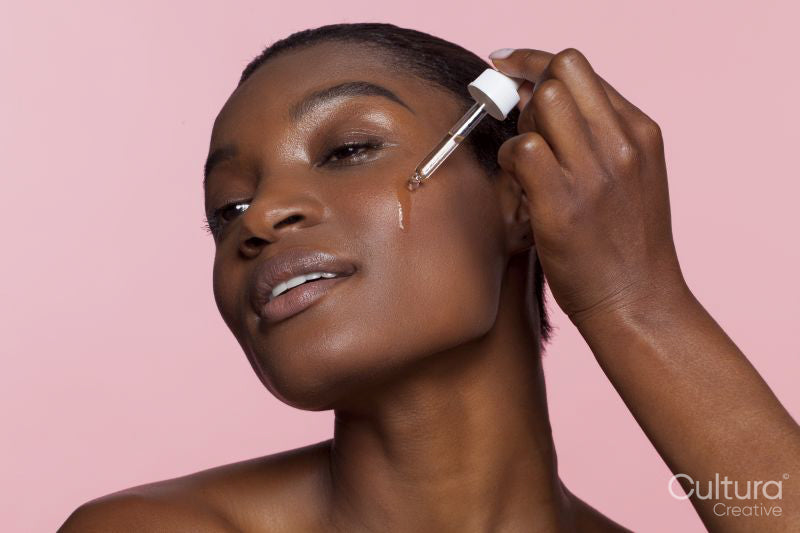 Young woman applying face serum