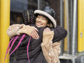 Two young women hugging in street