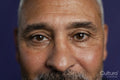 Close-up of man looking at camera against purple background