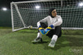 Female goal keeper sitting on ground