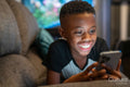 Boy with smart phone sitting on sofa
