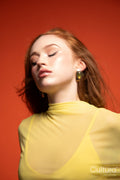 Woman in a yellow dress with windswept hair in a studio
