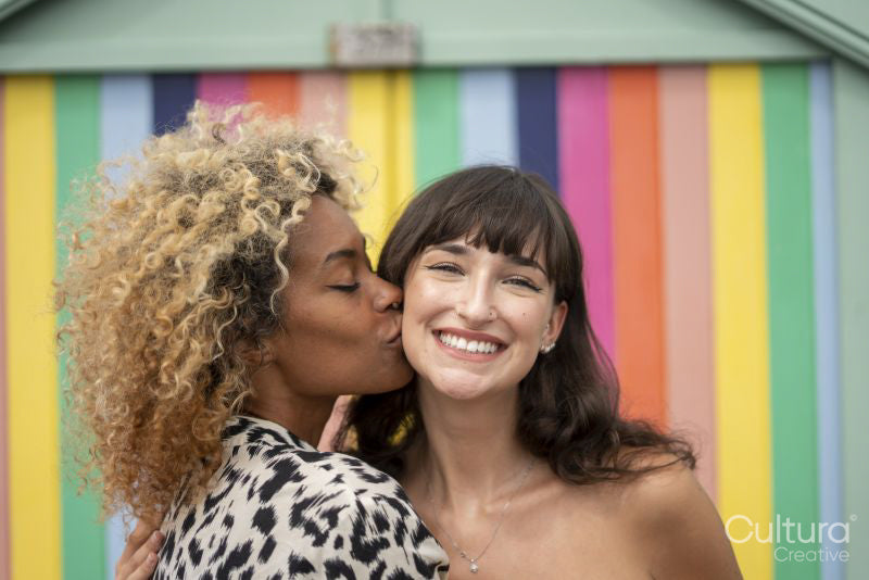 Woman kissing girlfriend on cheek