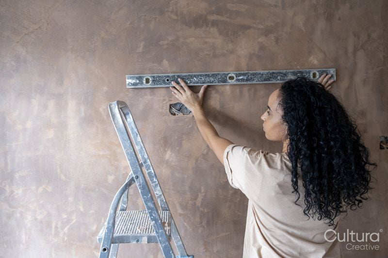 Woman using spirit level on wall