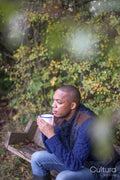 Man sitting on bench and having warm drink in nature