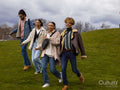 Group of young friends walking across lawn