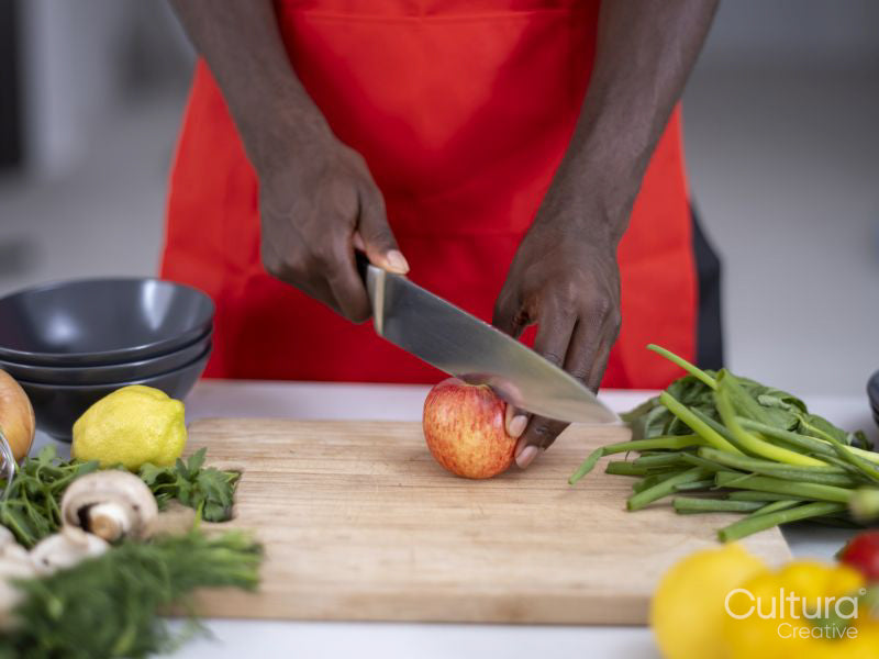 Midsection of person cutting apple