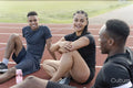 Group of athletes resting at sports track after training