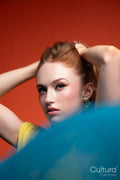 Woman in yellow dress veiled by blue sheer fabric