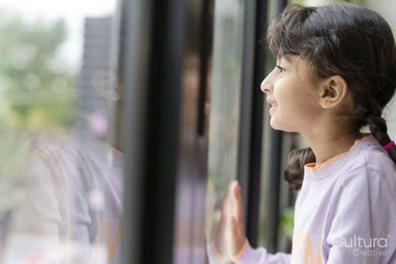 Little girl looking out window