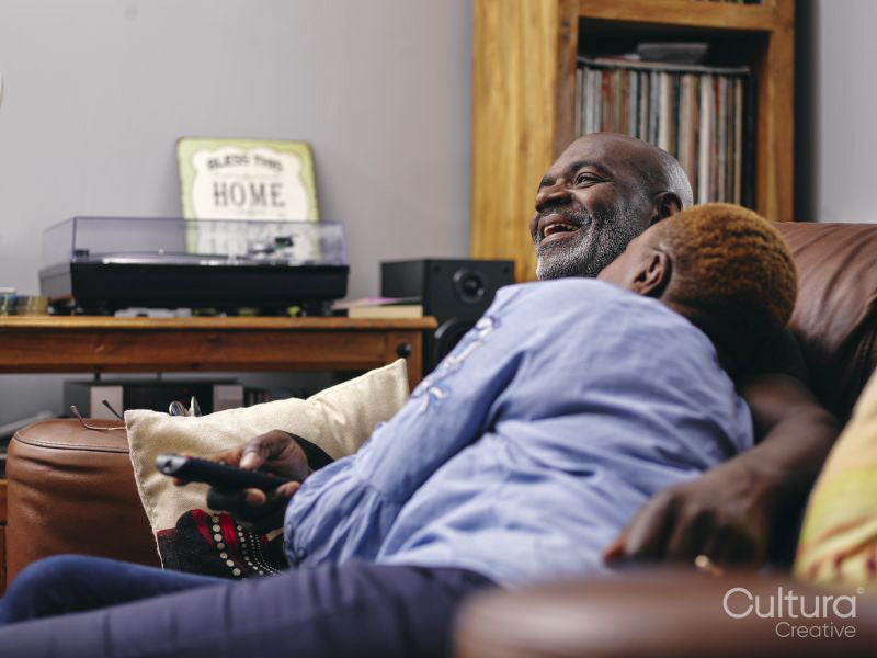 Couple sitting on sofa and watching tv