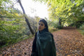 Portrait of woman standing on footpath in forest