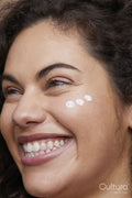 Close-up of young woman applying face cream