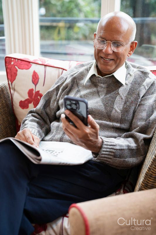 Smiling senior man using smart phone