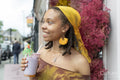 Portrait of young woman drinking smoothie in city