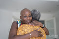Smiling woman hugging mother at home
